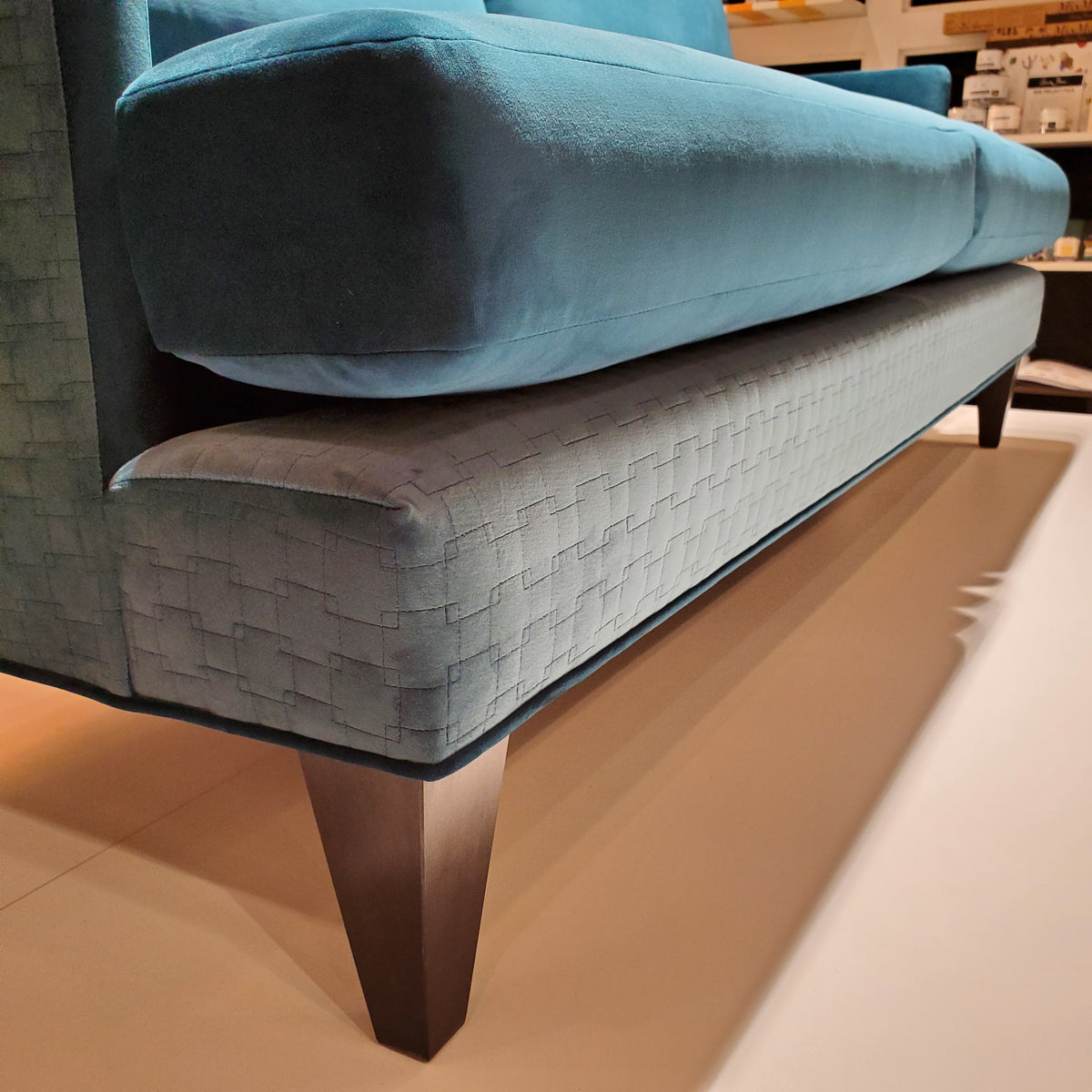 close up of custom sofa in brilliant Peacock Teal velvet and quilted geometric pattern 